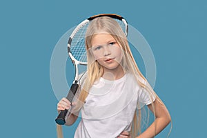 Overconfident elementary school girl with tennis racket