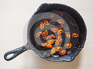 Overcooked onion in a pan. A bad kitchen. The concept of harmful food and carcinogens.