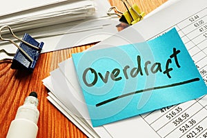 Overdraft sign and stack of accounting documents photo