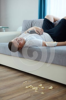 Overeat fat boy sleep on sofa in living room
