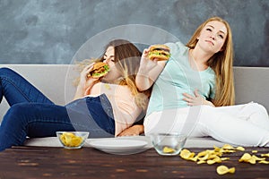 overeaten women sitting with lots of fast-food