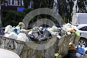 overfilled public trash bins at summer day in large city, close-up