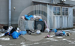 Overflowing garbage cans and rubbish lying around. The wind blows rubbish and trash bags. The concept of environmental
