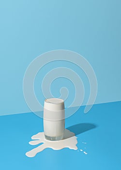 Overflowing glass of milk isolated on a blue background photo