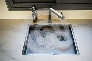 Overflowing kitchen sink, clogged drain.