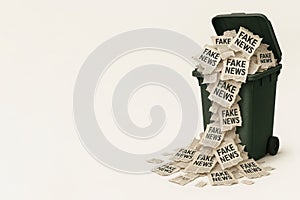 An overflowing trash can with fake news. Space for text.