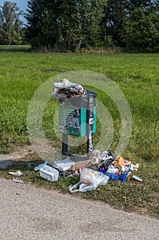 overflowing trash can in a park