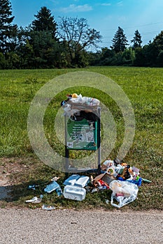 overflowing trash can in a park