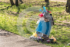 Overfull rubbish bin in park - waste, plastic bags, dog poo,