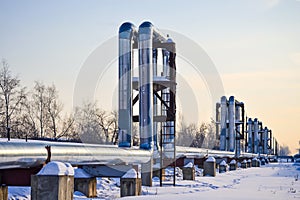 Overground heat pipes. Pipeline above ground, conducting heat for heating the city. Winter. Snow. photo