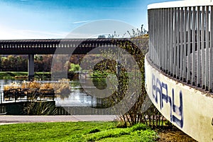 Overground tube bridge over a water pond next to a green park in Prague during the daytime