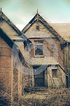 A overgrown brick mansion on a winter day