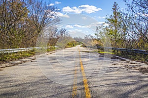 Overgrown road in the country with clouds and blue skies