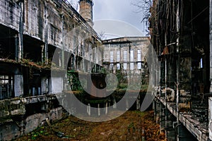 Overgrown ruins of industrial building. Abandoned, destroyed by war power plant in Tkvarcheli Tquarhcal, Abkhazia, Georgia