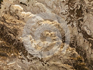 Overhead aerial shot of a yellowish moonscape in remote location desert area. Golden hour sunset view