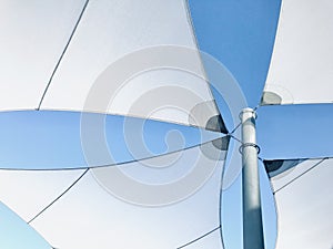 Overhead awning in white against blue sky background.