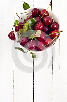 Overhead of bowl of red cherries in white dish