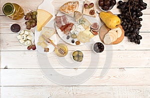 Overhead of cheese plate with pieces moldy cheese, prosciutto, p