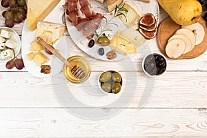 Overhead of cheese plate with pieces moldy cheese, prosciutto, p