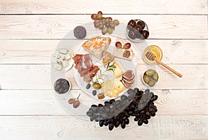 Overhead of cheese plate with pieces moldy cheese, prosciutto, p