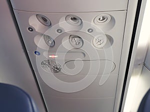 Overhead console in the modern passenger aircraft. Air conditioner button and lighting switch.