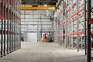 Overhead crane and compact forklift trucks in a empty industrial warehouse building