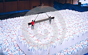 Overhead crane lift jumbo bags of tapioca using spread bar in storage warehouse. Bulk cargo in jumbo bag handling equipmet.