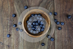 Overhead Display of Fresh Blueberries in a Rustic Wood Bowl