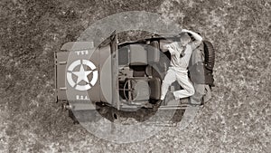 Overhead, drone, looking down on Male army officer in uniform resting on back of military vehicle