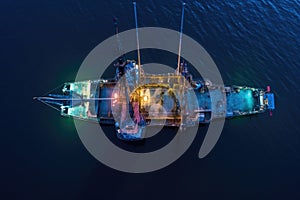 overhead drone view of fishing trawler at dusk
