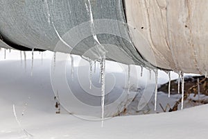 Overhead heat pipes. Winter, snow on the pipe