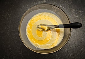Overhead image of whisked eggs in a glass bowl photo