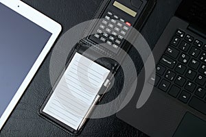 Overhead of office table with notebook, computer keyboard, table