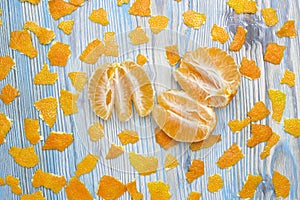 An overhead photo of tangerine without peel. Rustic background. Exotic fruits. Peeled juicy tangerine on the wooden blue table and