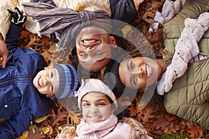 Overhead Portrait Of Family Lying In Autumn Leaves