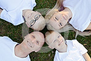 Overhead portrait on family lying on grass in park