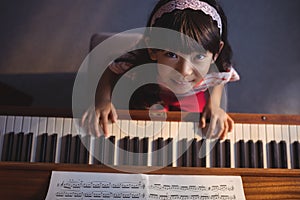 Overhead portrait of girl playing piano in classroom