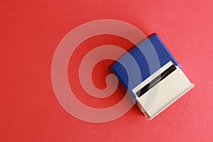 Overhead shot of an automatic ink stamp manufactured in blue plastic