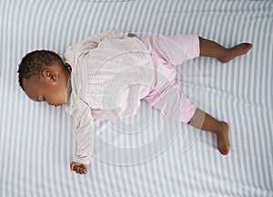 Overhead Shot Of Baby Girl Sleeping In Nursery Cot