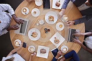 Overhead Shot Of Businesspeople Meeting In Coffee Shop