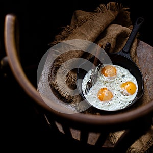 Overhead shot of cast-iron pan with three fried eggs