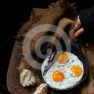 Overhead shot of cast-iron pan with three fried eggs