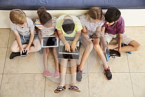 Overhead Shot Of Children Sitting On Floor Using Technology