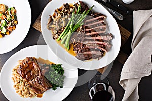 Overhead shot of a dinner table with steak and grilled pork