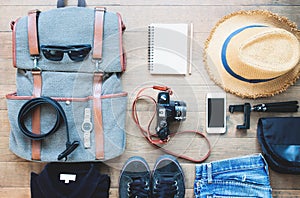 Overhead shot of essentials for traveler. Outfit of young man traveler, camera, mobile device, sunglasses.