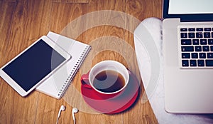 Overhead shot of laptop, tablet, coffee and headphones