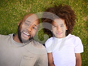 Overhead Shot Of Loving Father And Son Lying On Grass Together