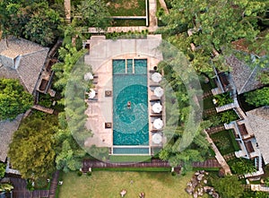 Overhead shot of a man swimming in the pool surrounded by trees