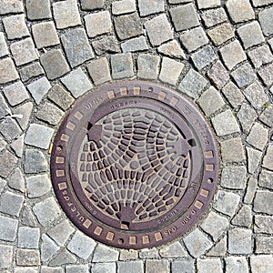Overhead shot of the metal cover of a sewer in Oslo.