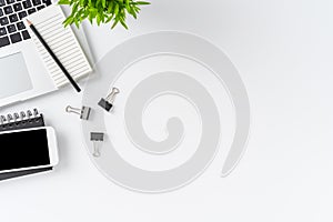 Overhead shot of modern workplace with laptop and accessories on white table with copyspace. Office desktop.